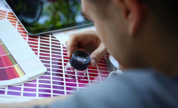 Photo male serviceman hold in hand magnifying glass making colour test