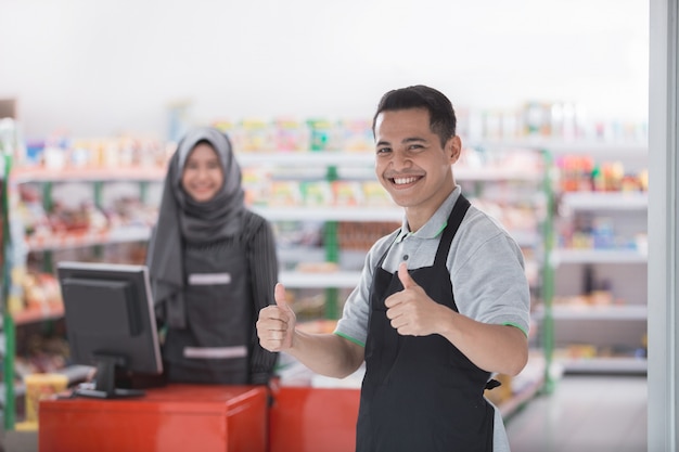 Male shopkeeper showing thumb up