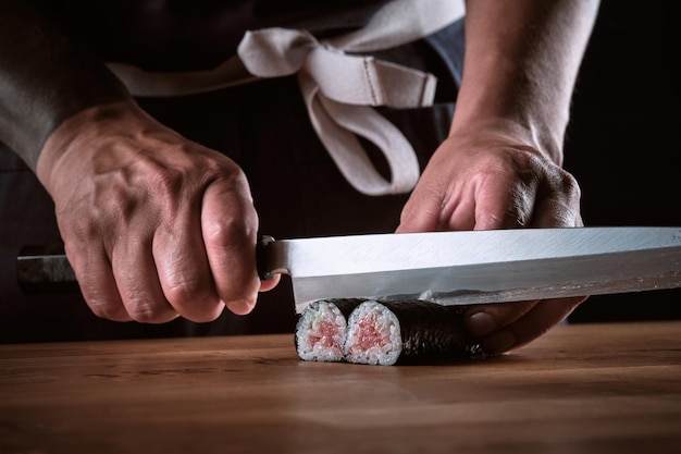 Photo male shushi man hands preparing different pieces of makis