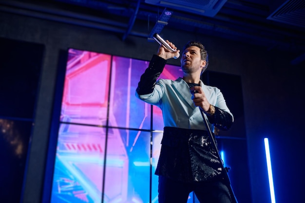 Male singer holding microphone standing and performing on stage