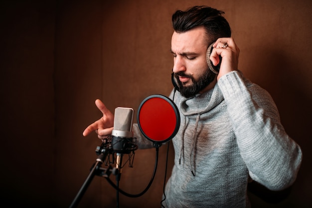 Male singer recording a song in music studio