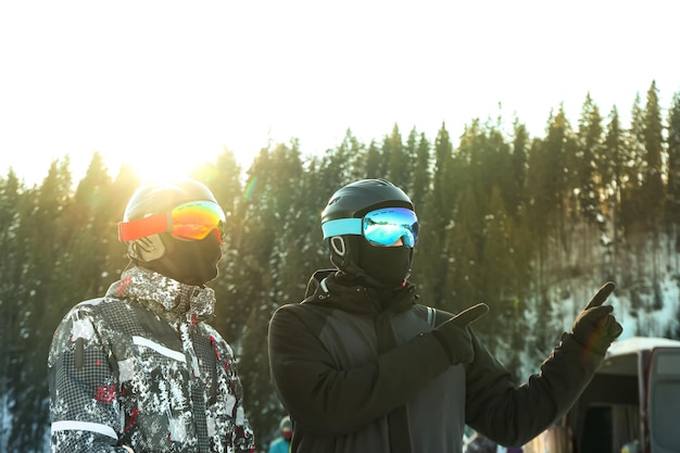 Male skiers in ski helmets and goggles in mountain resort