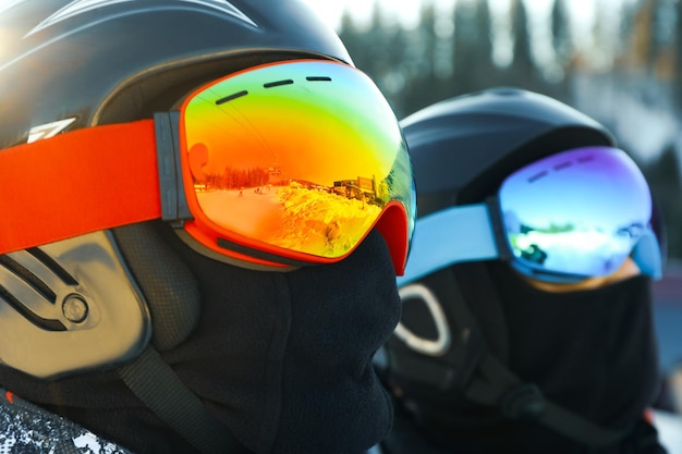 Male skiers in ski helmets and goggles in mountain resort