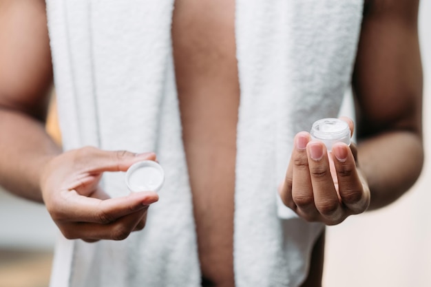 Male skincare cosmetic product cream jar in hand