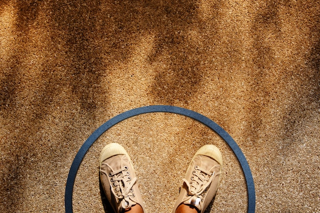 Male on Sneaker Shoes Standing inside a Circle Line