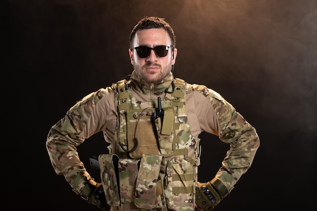 Male soldier in camouflage on dark wall