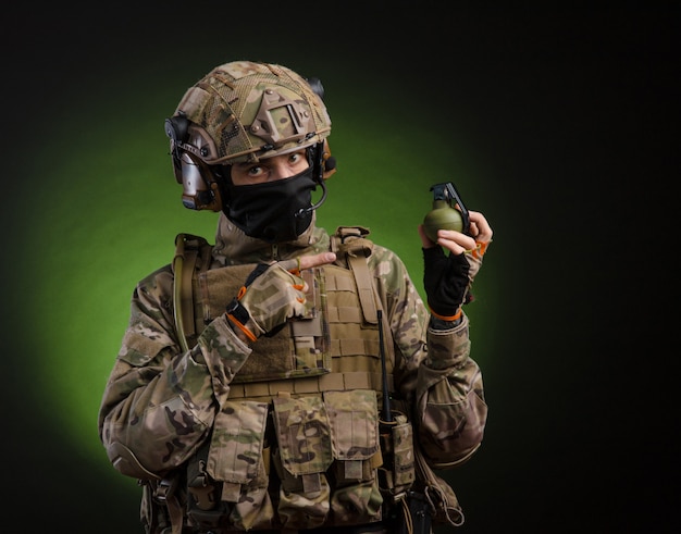 Male soldier in military dress with weapon on dark background
isolated on black filmed on wide angle