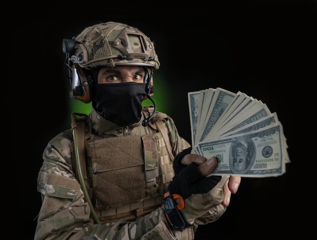 Male soldier in military dress with weapon on dark background isolated on black filmed on wide angle