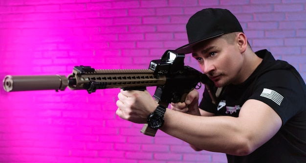 A male special agent with an automatic airsoft rifle on a neon\
background