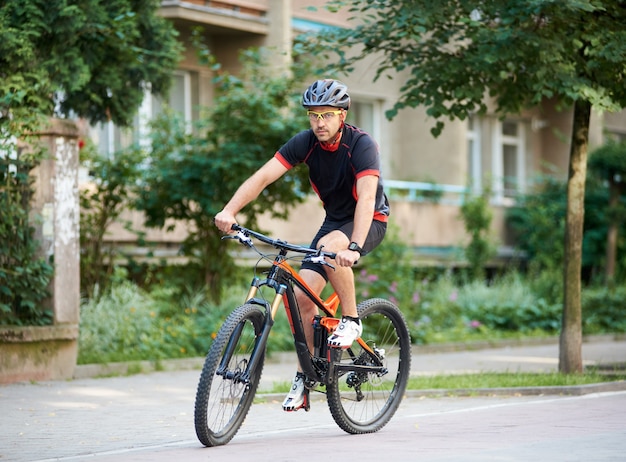 男性のスポーツマンが屋外の自転車でサイクリング