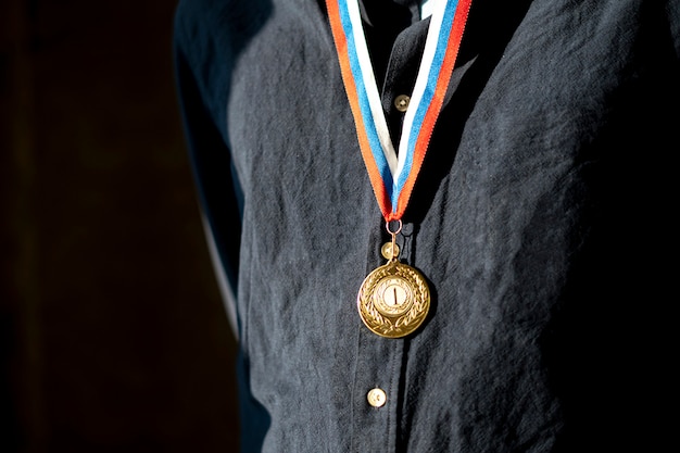 A male sportsman with a golden medal on a chest, champion leader