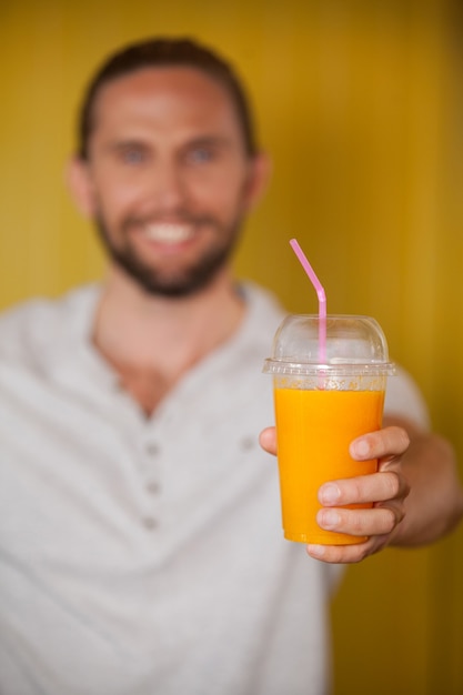 Male staff holding orange juice glass at organic section