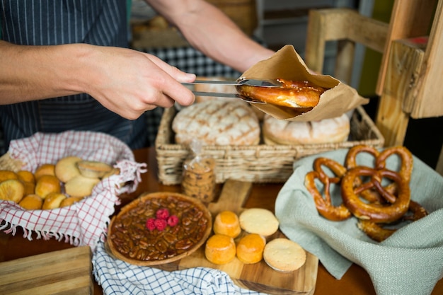 Male staff packing pretzel in paper bag