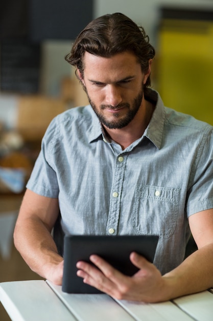 Personale maschile utilizzando la tavoletta digitale nel negozio di alimentari