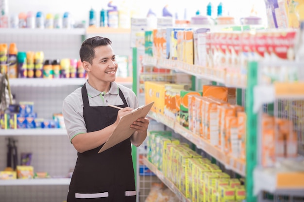 Male staff with note in supermarket