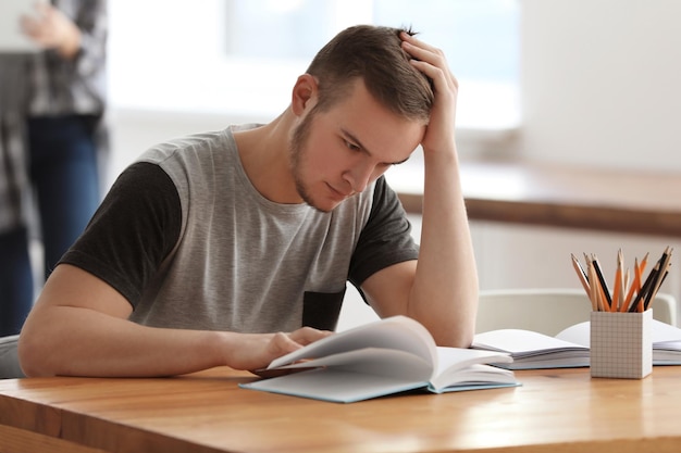 Male student doing homework in library