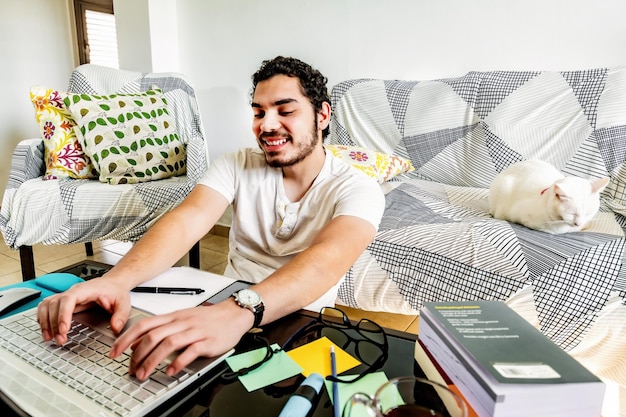 Foto studente maschio che trova informazioni online a casa