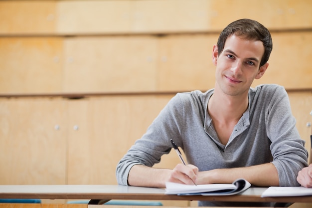 Male student holding a pen