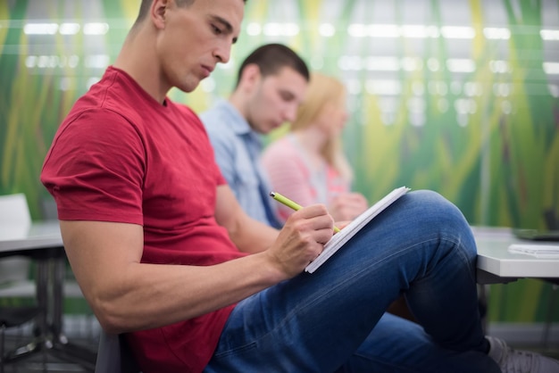 male student taking notes in classroom. business education concept, casual young businessman on seminar training