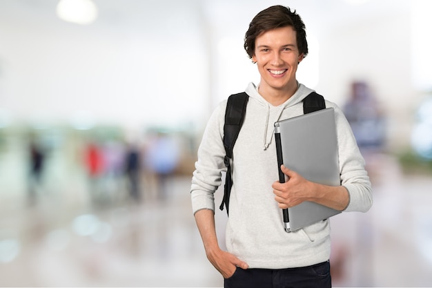 Male student with laptop on background