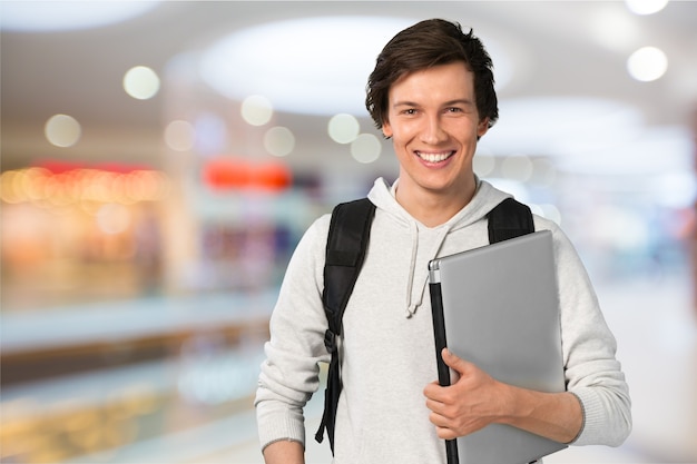 Foto studente maschio con laptop sullo sfondo