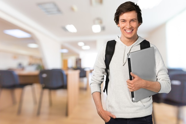 Studente maschio con laptop sullo sfondo