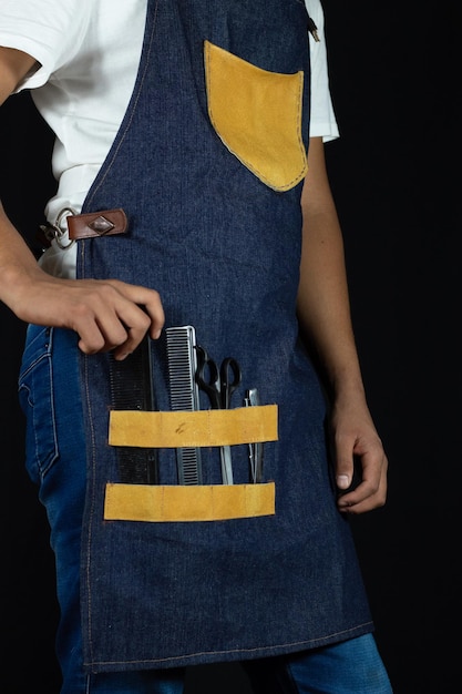 Photo male stylist taking a cutting comb from his work apron