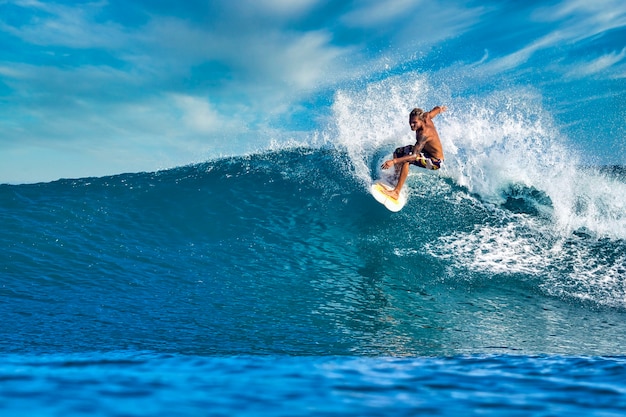 Photo male surfer on a blue wave at sunny day