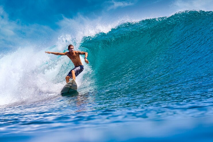Photo male surfer on a blue wave at sunny day