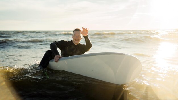 A male surfer goes in for sports at sea uses a surfboard in a\
wetsuit