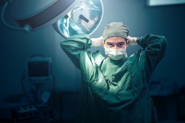 写真 手術室でマスクを結ぶ男性外科医