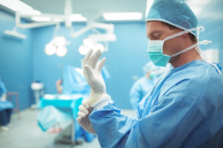Photo male surgeon wearing surgical gloves in operation theater