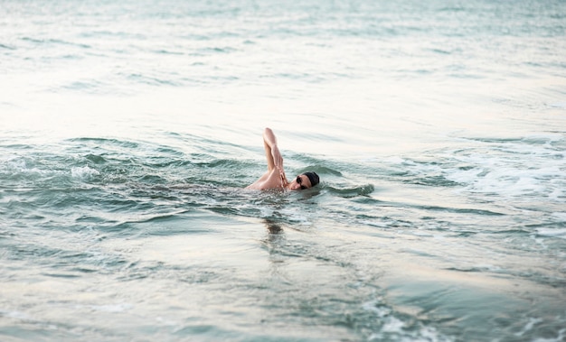 Foto nuotatore maschio che nuota nell'oceano con lo spazio della copia