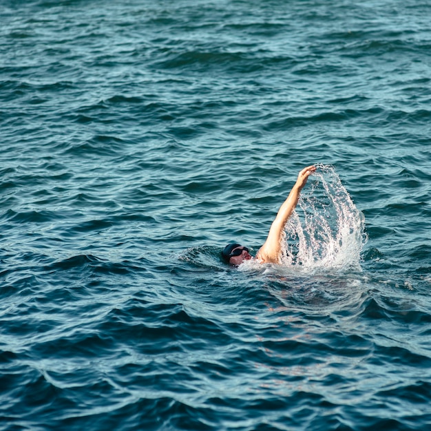 Foto nuotatore maschio che nuota in acqua con lo spazio della copia