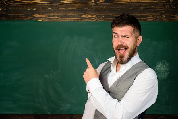 Male teacher over green chalkboard background school student portrait of college student in college