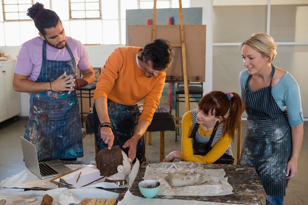 Photo male teacher showing sculpture to adult student