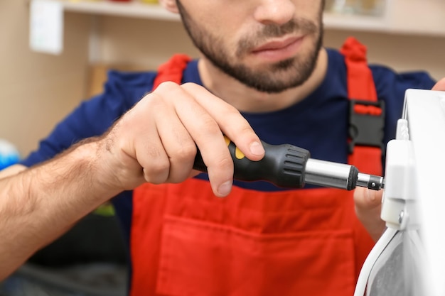 Male technician repairing refrigerator closeup