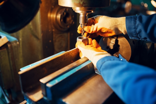 Male technician works on lathe, plant