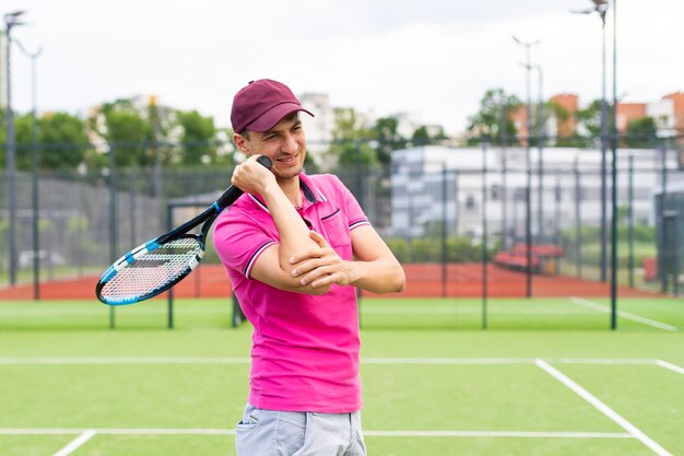 Male tennis player at the court looking happy