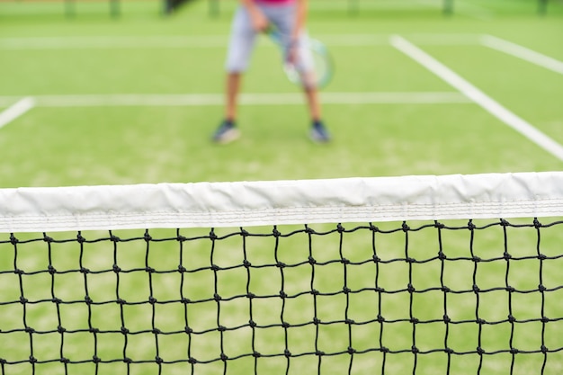 Giocatore di tennis maschio alla corte che sembra felice