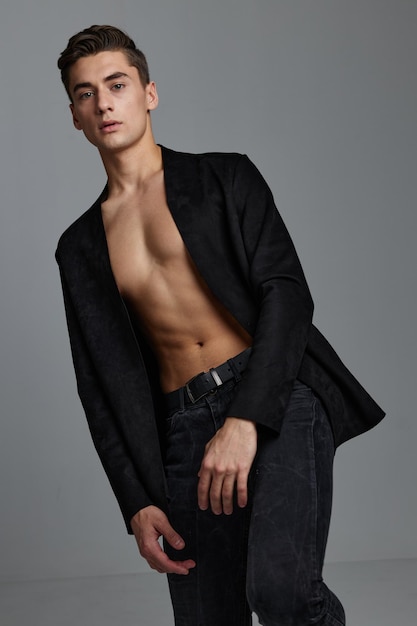 Male topless in dark suit on gray background cropped view