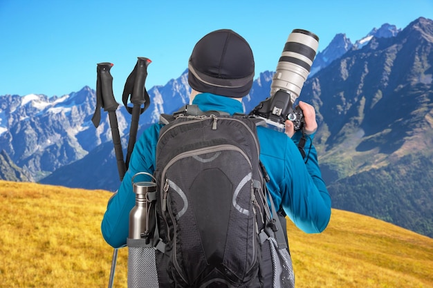 male tourist photographer with a backpack looks at the beauty of nature