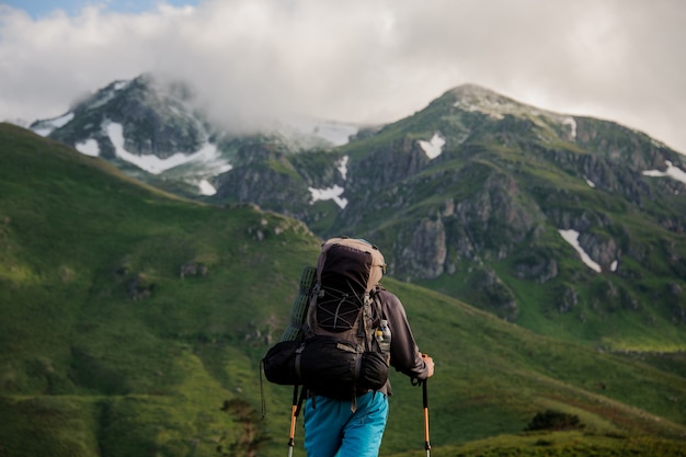 Male tourist stands in front of mountains