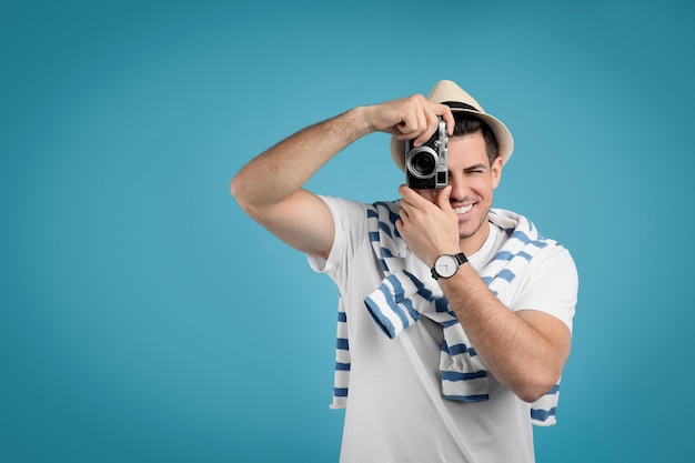 Male tourist taking picture on turquoise background space for text