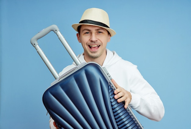 Male tourist with a suitcase in his hands, hand Luggage of a tourist