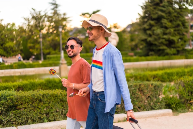 자부심 축제 lgbt 개념을 위해 도시를 방문하는 도시에서 일몰에 공원에서 가방을 들고 남성 관광객 게이 남자 친구