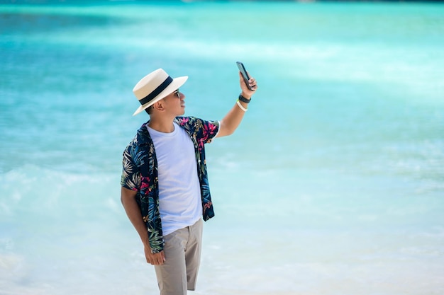 Male tourists playing mobile phones in the middle of the sea in Thailand