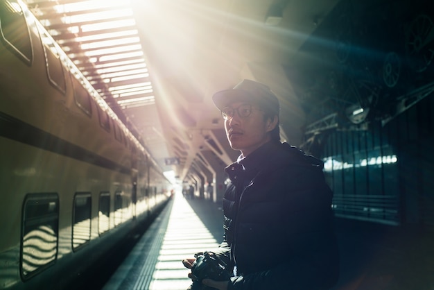 Foto turisti maschii che aspettano treno