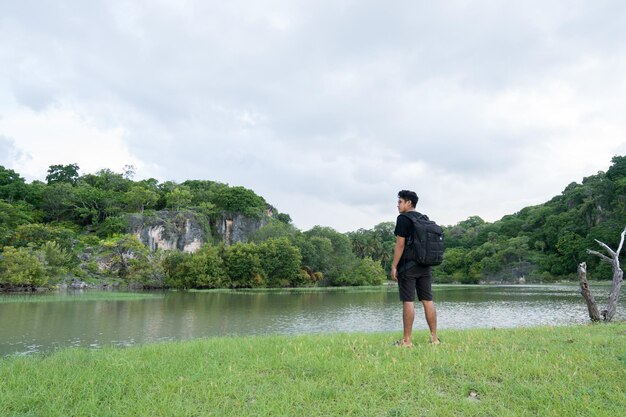 Male traveler enjoying the beautiful forest at the river estuary