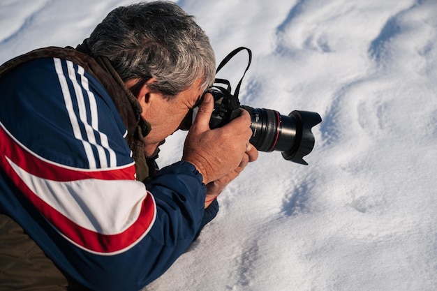 男性旅行者の写真家は自然の中で現代のデジタル一眼レフ カメラで撮影します。